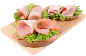 Delicious sandwiches with lettuce and ham isolated on white