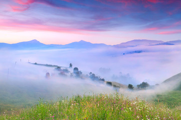 Panorama of the mountains and village in the morning mist. Summe