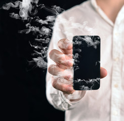 Rauchendes Smartphone in der Hand einer Person