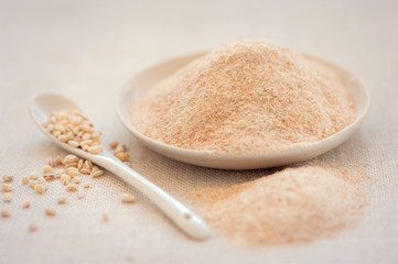 Цельнозерновая мука в фарфоровом блюдце с фарфоровой ложечкой