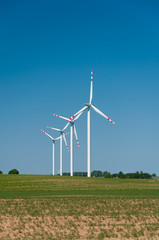 green meadow with Wind turbines generating electricity