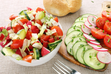 Salad with fresh vegetables in white bowl