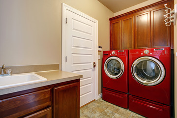 Laundry room with modern red appliances