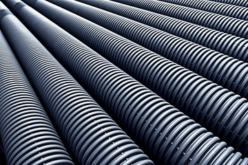 Close up of black plastic pipes with diminishing perspective - obrazy, fototapety, plakaty