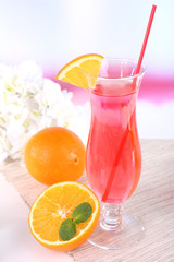 Glass of cocktail on table on light background