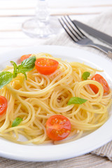 Delicious spaghetti with tomatoes on plate on table close-up