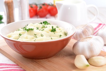 Delicious mashed potatoes with greens in bowl on table close-up