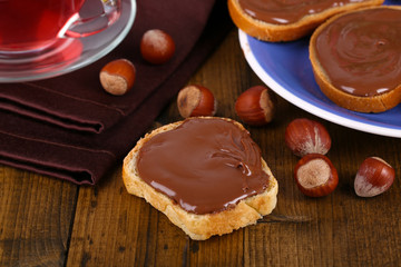 Bread with sweet chocolate hazelnut spread on plate on table