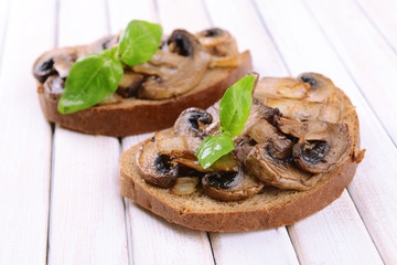 Delicious bruschetta with mushrooms on table close-up