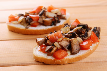 Delicious bruschetta with mushrooms on table close-up