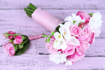 Beautiful wedding bouquet and boutonniere on wooden background