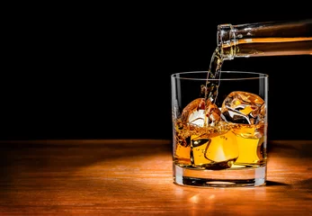 Foto op Plexiglas Alcohol Whiskydrank in glas gieten