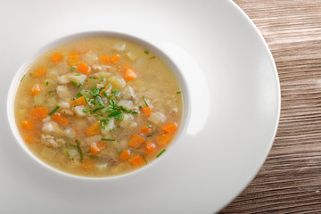 Bone Broth in Soup Bowl Served with Fresh Herbs, Garlic