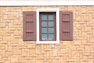 Windows of homes with brick wall surround.