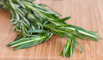 Fototapeta premium Rosemary branch on a chopping wooden board