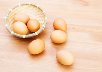 Brown egg in basket over wooden texture