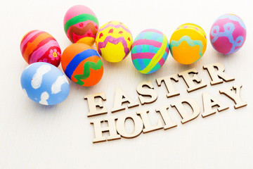 Colourful painted easter egg with wooden text