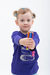 Little girl shows a stack of pencils