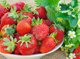 Strawberries in a plate on wicker tablecloth