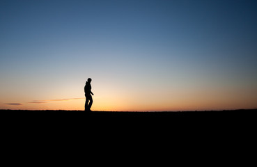 silhouetted man in sunset