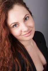 Naklejka premium Portrait of young pretty woman with long red curly hair
