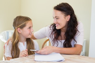 Mother and daughter with mobile phone in house