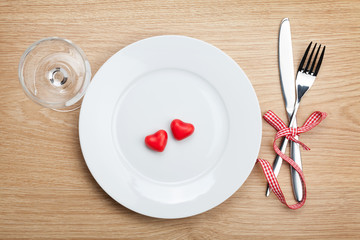 Valentine's Day heart shaped candy over plate with silverware an
