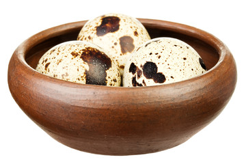 Three quail eggs on a brown plate