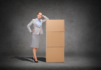 smiling businesswoman with cardboard boxes - Powered by Adobe