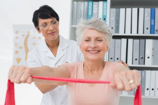Female physiotherapist massaging senior womans back