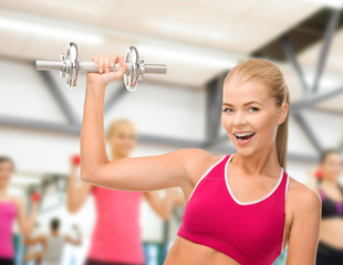 smiling woman with heavy steel dumbbell