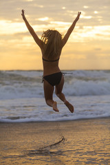 Fototapeta na wymiar Bikini Woman Girl Jumping Sunset Sunrise Beach