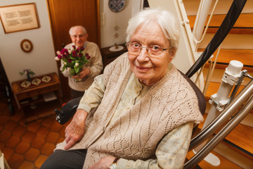 elderly couple in the staircase with stairlift