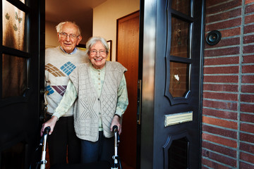 elderly couple opening the front door - 63423834