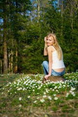 Young pretty blond woman on a meadow flowers