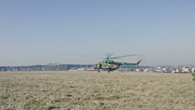 Soldiers jump out of a helicopter.