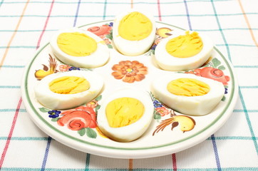 Halves of eggs lying on colorful plate