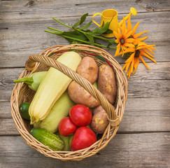 Basket with vegetables and a bouquet of yellow rudbeckia