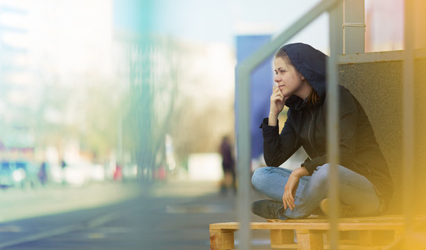 Woman sitting in city. Street photo.