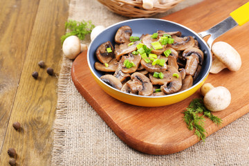 Delicious fried mushrooms in pan on table close-up