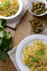 Delicious pasta with pesto on plate on table close-up