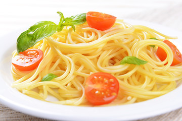 Delicious spaghetti with tomatoes on plate on table close-up