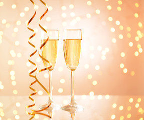 Glasses of champagne on shiny background
