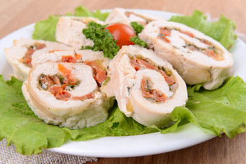 Delicious chicken roll on plate on table close-up