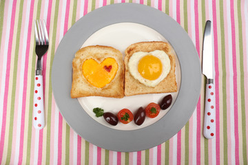 Scrambled eggs with bread on plate, on color napkin