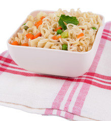 Tasty instant noodles with vegetables in bowl on table close-up