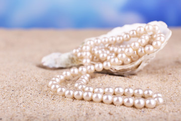 Beautiful pearls in shell on sand, close up