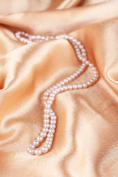 Beautiful pearls on golden silk cloth