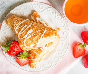 Fresh croissants with strawberries on wooden background