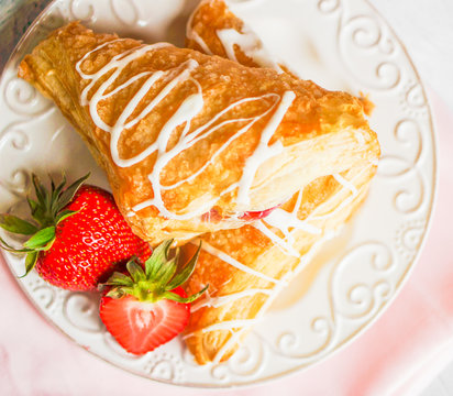 Fresh croissants with strawberries on wooden background
